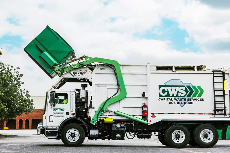 Collection truck lifting dumpster to empty into truck