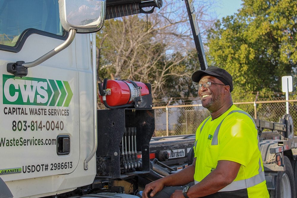 CWS employee smiling while standing by a truck