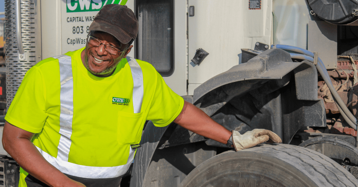 Capital_Waste_Services_driver_maintaining_truck_with_checking_tire_pressure.png